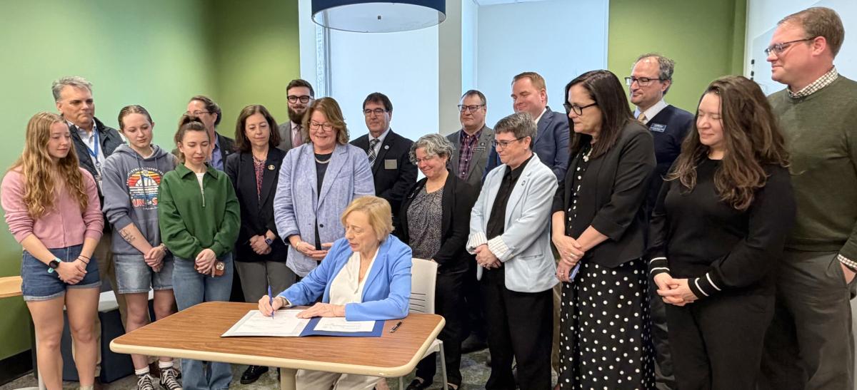Governor Mills ceremonially signs the budget provision raising Maine's minimum teacher pay